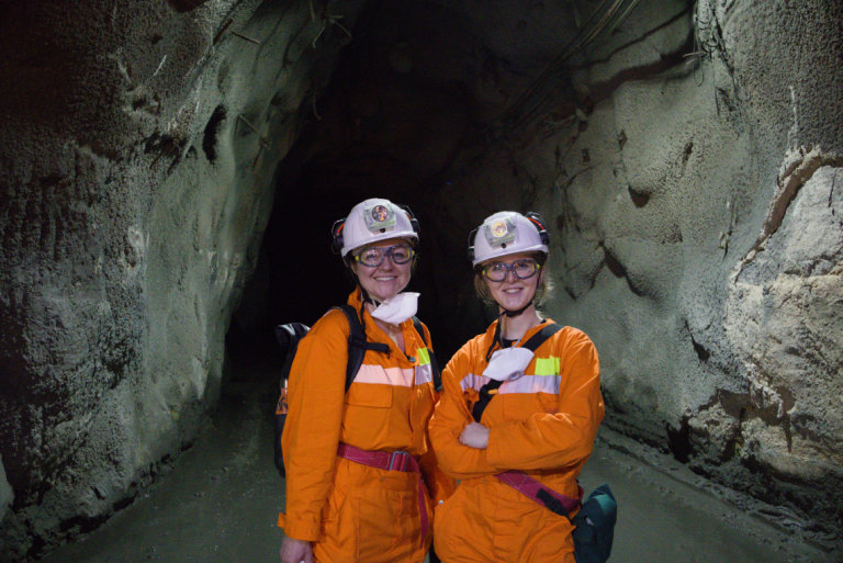 Sarah Gordon and Helen Bargmann on set wearing PPE in an underground mine.