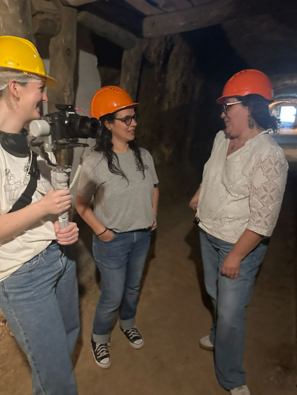 Producer Helen Bargmann speaking to two women in an underground mine.