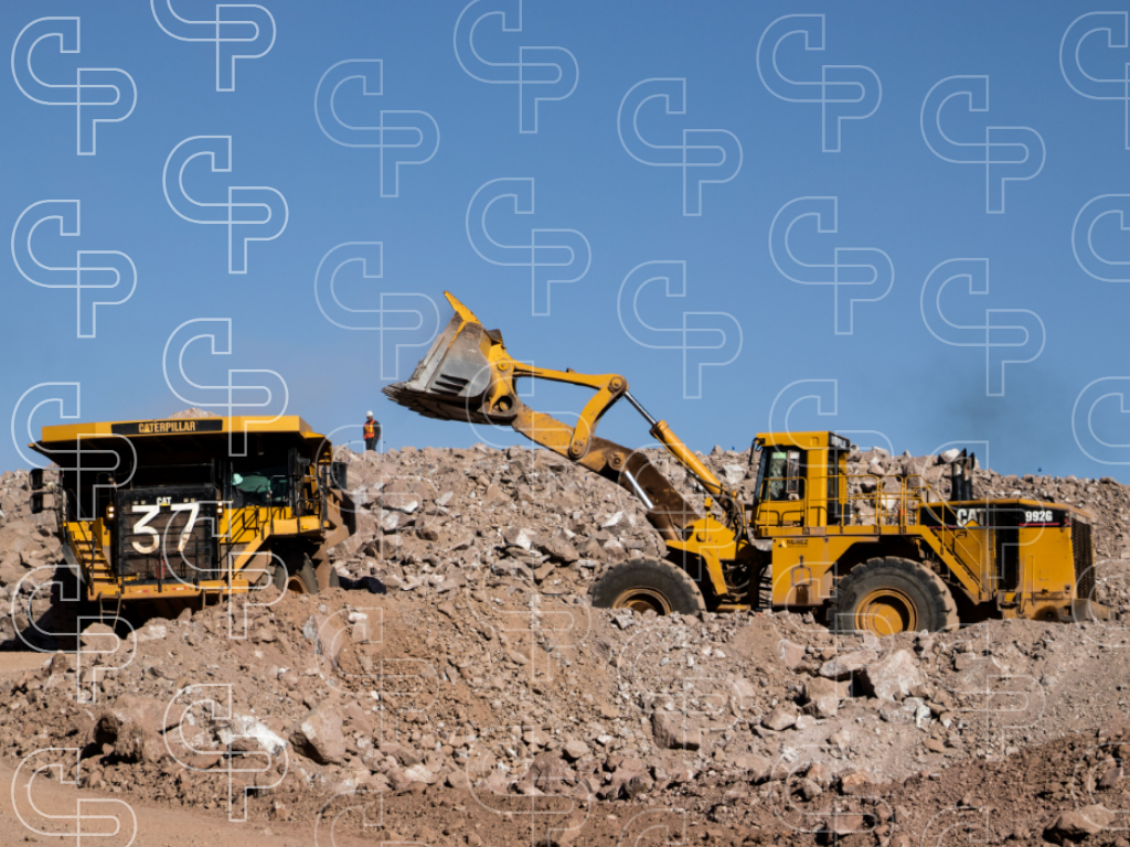 Wheel loader transferring broken rock into a Caterpillar haul truck on a mine site.